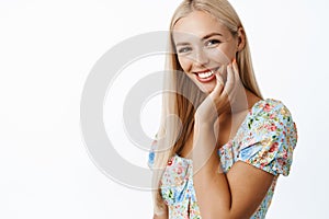 Skin care and women beauty. Attractive blond young woman touching her face expression, gazing romantic at camera and