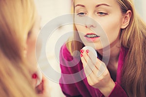 Woman using cotton pad to remove make up