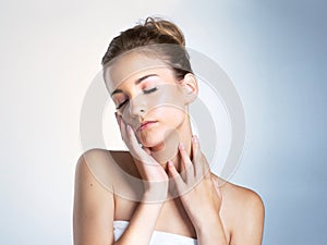 Skin doesnt get softer than this. Studio shot of a beautiful young woman with her eyes closed touching her neck and face