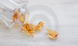 Skin and hair vitamin serum orange capsules on white table