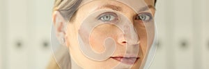 Skin tone cream lines on woman face close up.