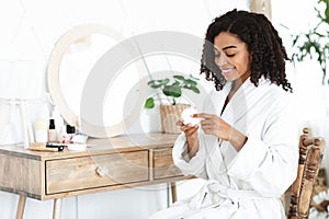 Daily Skincare. Beautiful Black Woman Using Moisturising Cream For Skin At Home