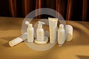 Skincare beauty cosmetic concept. White tube of cream lotion cleanser antioxidant facial oil on brown background
