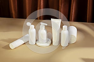 Skincare beauty cosmetic concept. White tube of cream lotion cleanser antioxidant facial oil on brown background