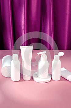 Skincare beauty cosmetic concept. White tube of cream lotion cleanser antioxidant facial oil on pink background