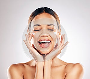 Skincare, beauty and happy woman with face cream in studio for healthy, glowing or anti aging on grey background. Facial