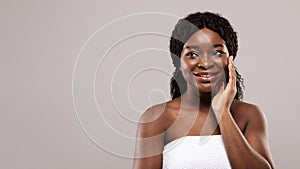 Skincare Concept. Beautiful Black Woman Touching Her Smooth Skin And Looking Aside