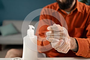 skincare concept. Close-up of man hands moisturising them with cream for dry skin.