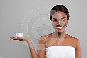 Skincare Cosmetic. Young Smiling Black Woman Holding Jar With Moisturising Cream