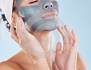 Skincare, facial and beauty with woman with face mask for cosmetics luxury, relax or acne against blue background studio