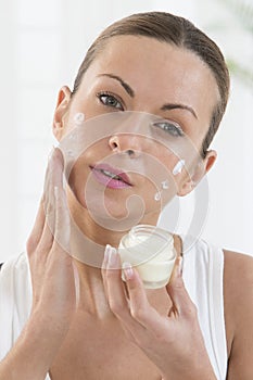 Skincare products - Beautiful women applying moisturizer