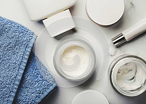 Skincare products.Cream jars,lotion, exfoliating cream and a blue towel photo