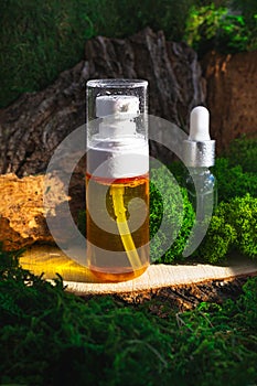 Skincare routine pipette bottles. Retinol, Hyaluronan, Antioxidant treatment Serum on green forest background