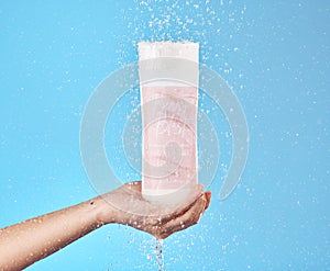 Skincare, soap product and bottle for shower gel cleaning, wellness and body hygiene with water. Hand holding plastic