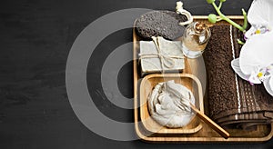 Skincare spa with clay mask,natural soap and oil in wooden tray