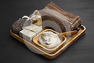 Skincare spa with clay mask,natural soap and oil in wooden tray