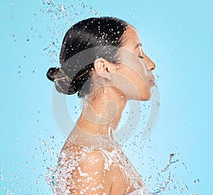 Skincare, water and profile of woman on blue background for wellness, healthy skin and cleaning in studio. Beauty