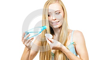 Woman cleaning her face skin with cotton pad