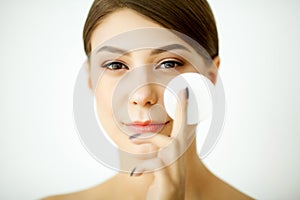 Skincare. Young woman with lotion washing face at bathroom