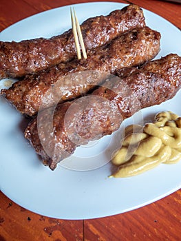 Skinless meat roll sausage or mici traditional balkan romanian ottoman cuisine delicacy served with mustard