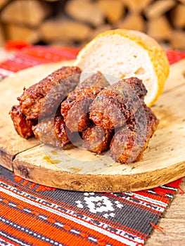 Skinless meat roll sausage or mici traditional balkan romanian ottoman cuisine delicacy served on a wooden plate in a rustic decor