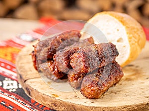 Skinless meat roll sausage or mici traditional balkan romanian ottoman cuisine delicacy served on a wooden plate in a rustic decor