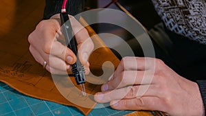 Skinner making decorative details on leather playing field