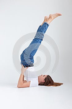 skinny caucasian pretty female lying on floor at white studio with legs raised