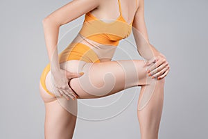 Skinny female thighs, legs and buttocks on gray background, lymphatic drainage massage concept