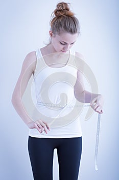 Skinny girl measuring waist