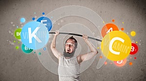 Skinny guy lifting colorful vitamin weights