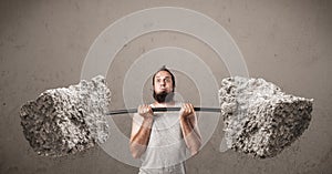 Skinny guy lifting large rock stone weights