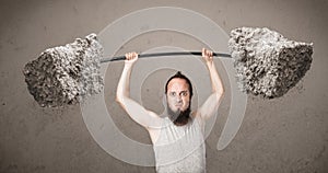 Skinny guy lifting large rock stone weights