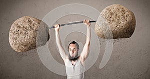 Skinny guy lifting large rock stone weights