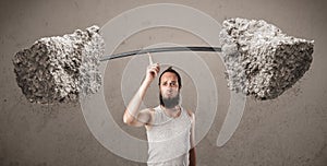 Skinny guy lifting large rock stone weights