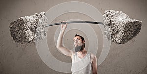 Skinny guy lifting large rock stone weights