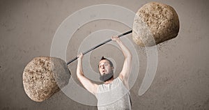 Skinny guy lifting large rock stone weights