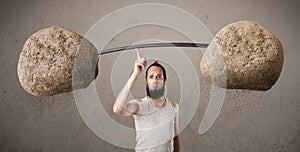 Skinny guy lifting large rock stone weights