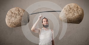 Skinny guy lifting large rock stone weights