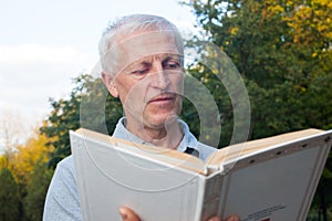 Skinny old man reading book