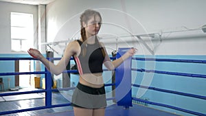 Skipping exercises, athlete female does exercise with jump rope on ring in sports center