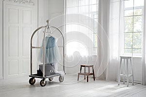 Skirt hanging on mobile hanger rack in minimalist white room interior. Hotel interiors, walk-in closet.