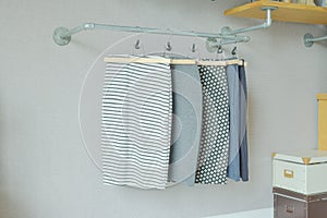 Skirts hanging on industrial style clothes rail in walk in close