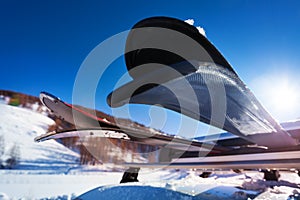 Skis on the car roof rails against blue sky