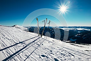 Skis are in deep snow on the ski track in sunny bright light