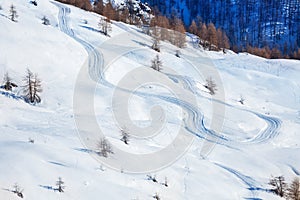 Skis or snowboarding traces on snow-covered slope