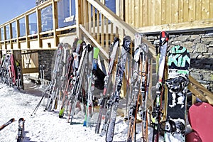 Skis and snowboards against apres ski chalet bar