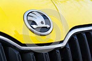 Skoda Auto automobile manufacturer from Volkswagen Group company logo on yellow dirty car