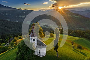 Skofja Loka, Slovenia - Aerial view of the beautiful hilltop Sveti Tomaz Saint Thomas church with an amazing sunset