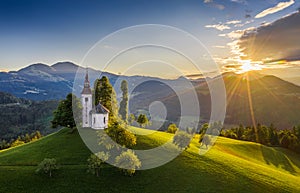 Skofja Loka, Slovenia - Aerial view of the beautiful hilltop Sveti Tomaz Saint Thomas church with a warm summer sunset